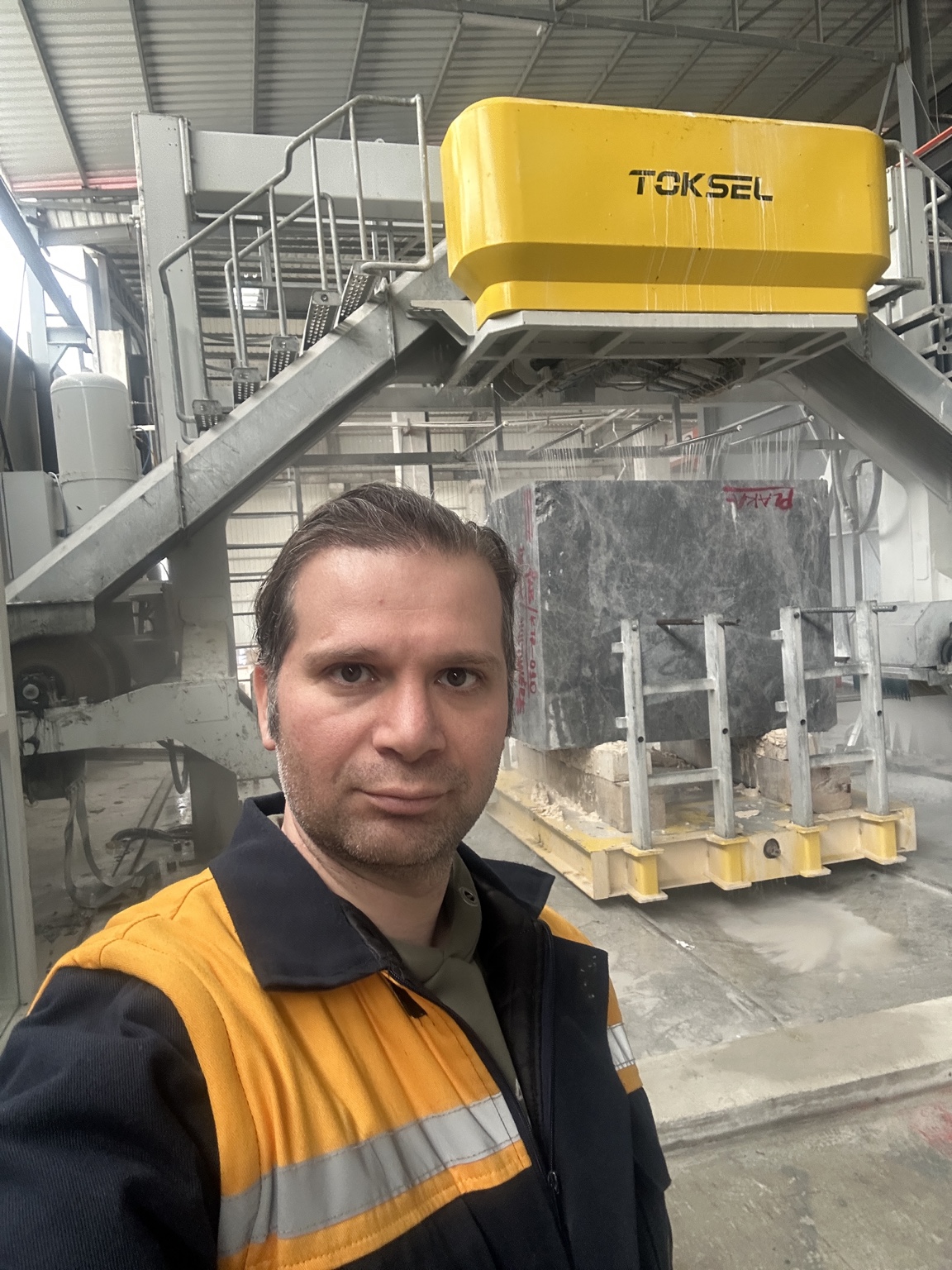 Ehsan Roshani beside a TOKSEL multi-wire saw in the workshop